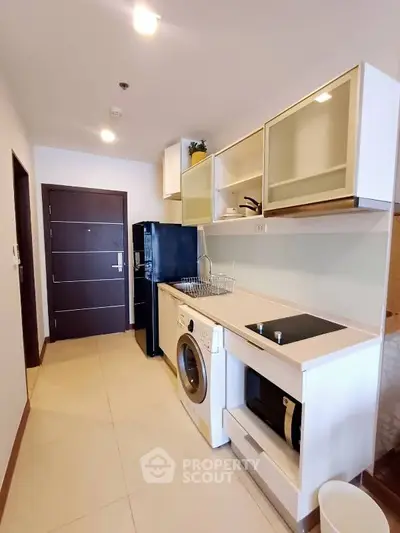 Modern kitchen with sleek appliances and ample storage in a stylish apartment.