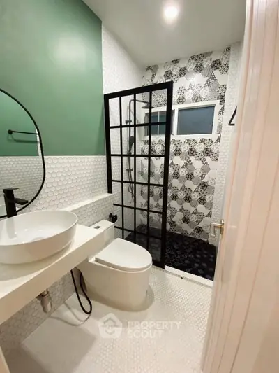 Modern bathroom with stylish black and white tile design and sleek fixtures.