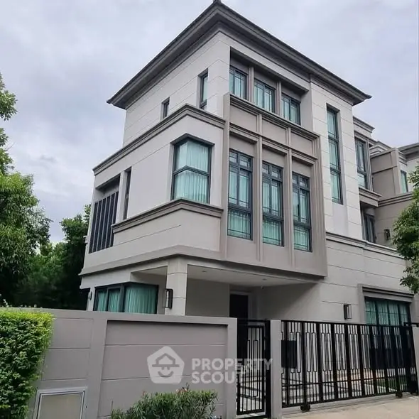 Modern multi-story residential building with sleek design and gated entrance.