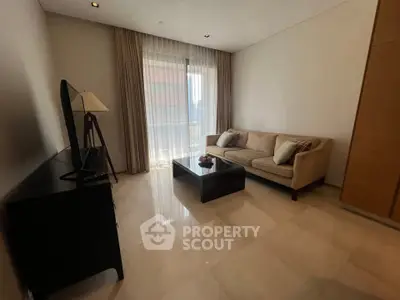Elegant living room with modern furniture and large window offering natural light.