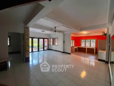 Spacious open-plan living room with large windows and tiled flooring, perfect for modern living.