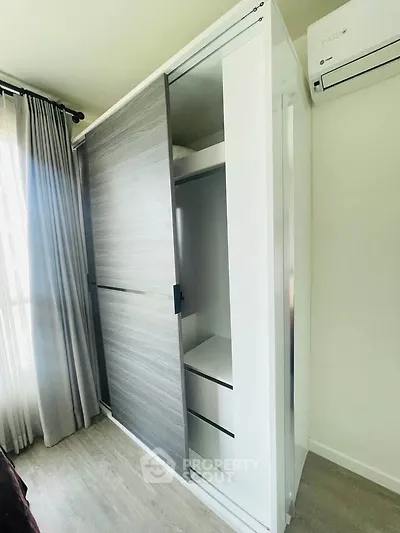 Modern bedroom with sleek sliding wardrobe and air conditioning unit