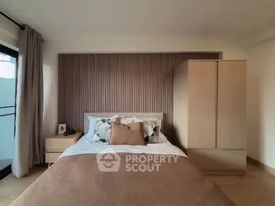 Modern bedroom with stylish decor and natural light, featuring a cozy bed and wooden wardrobe.