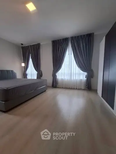 Spacious bedroom with elegant curtains and modern design