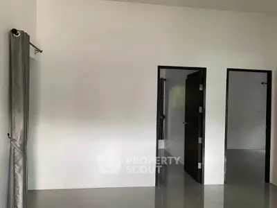 Minimalist interior with white walls and dark doors, showcasing a modern and clean design.