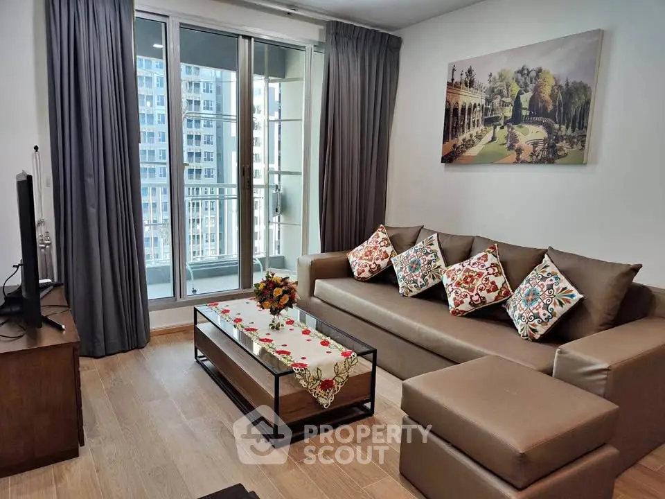 Stylish living room with modern decor and balcony view in urban apartment.