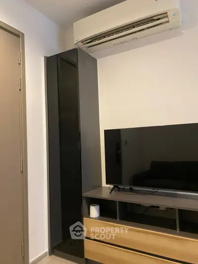 Modern living room with sleek TV setup and air conditioning unit.