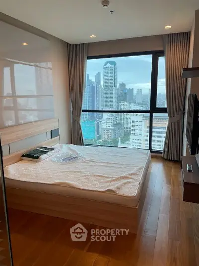Modern bedroom with stunning city view and wooden flooring