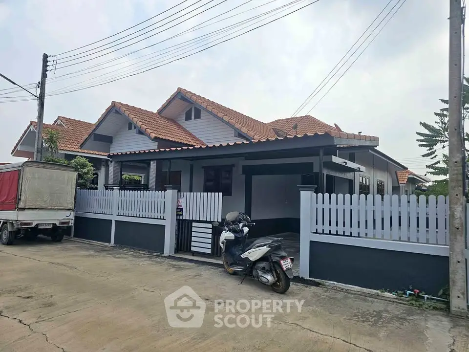 Charming suburban house with red-tiled roof and white picket fence, perfect for family living.