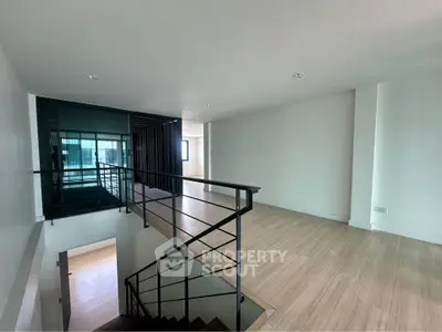 Spacious modern living area with sleek staircase and natural light