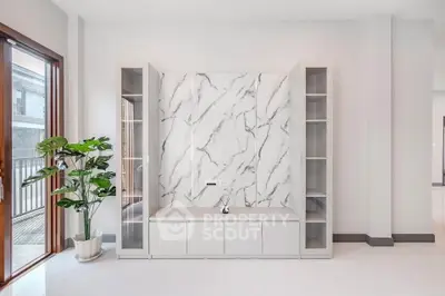 Modern minimalist living room with marble accent wall and natural light