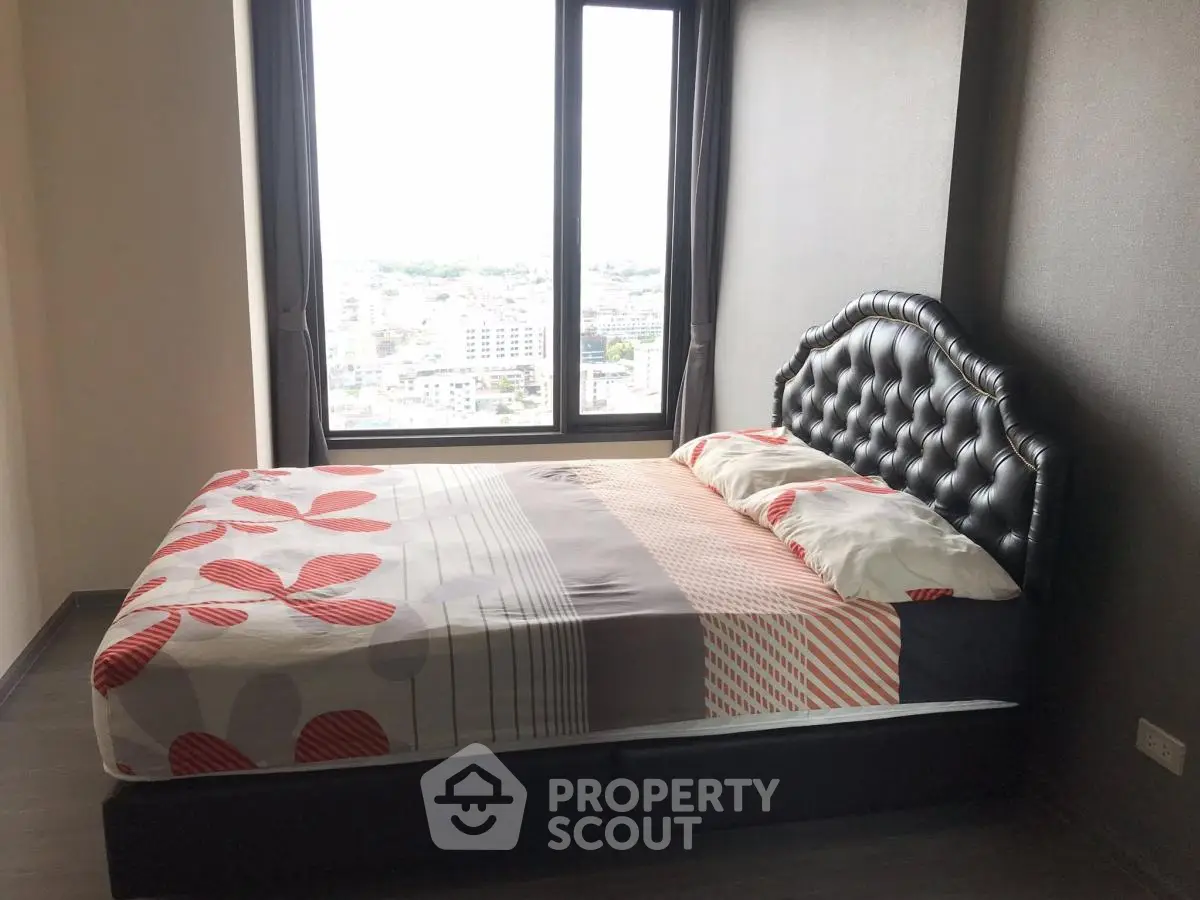 Modern bedroom with large window offering stunning city views