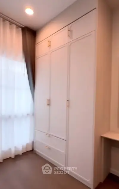 Spacious bedroom with elegant built-in wardrobe and natural light