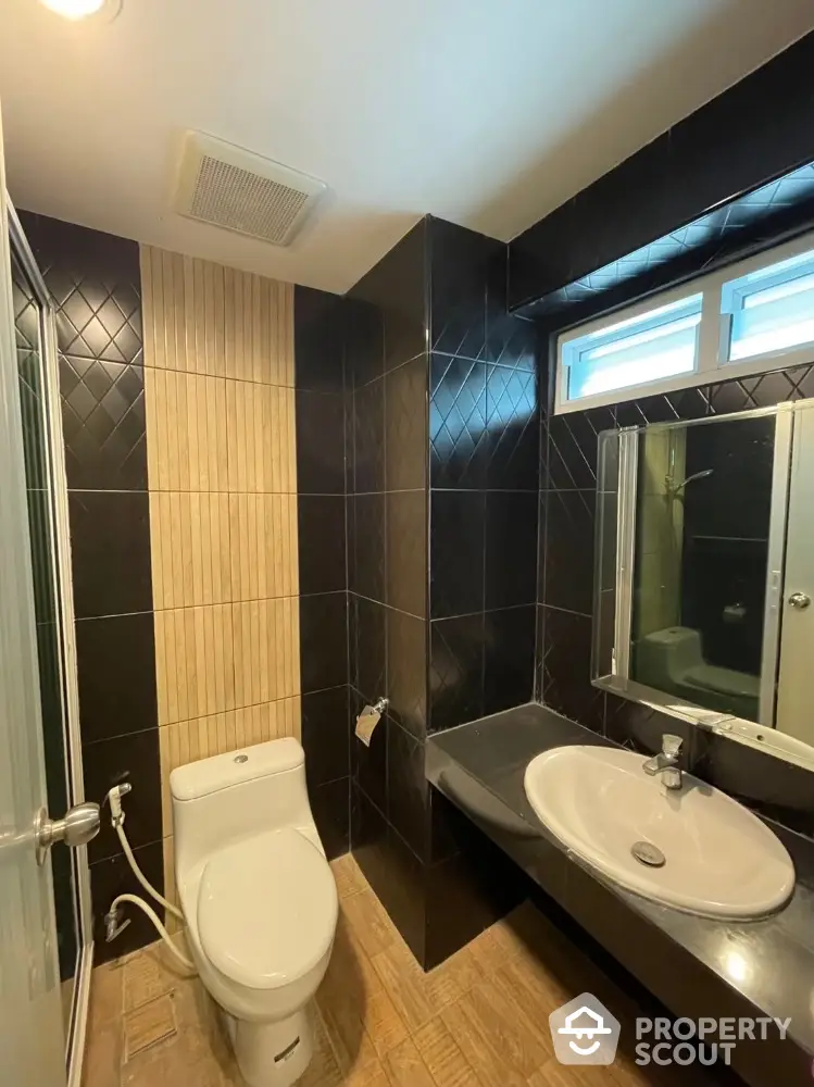 Modern bathroom with sleek black tiles and contemporary fixtures