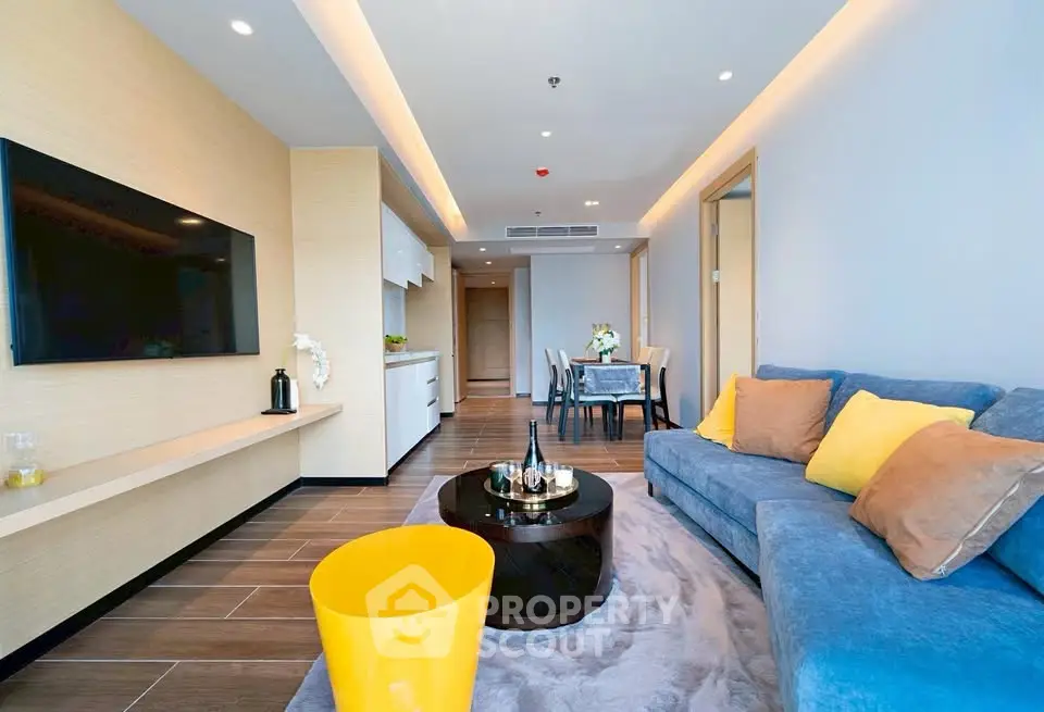 Modern living room with stylish decor and open layout, featuring a cozy sofa and sleek TV setup.
