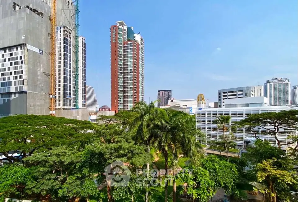 Stunning urban skyline view with lush greenery and modern high-rise buildings.