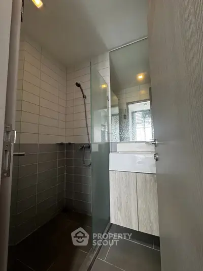 Modern bathroom with sleek shower and stylish vanity in contemporary apartment.