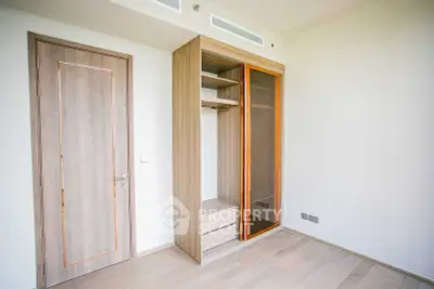 Spacious modern bedroom with built-in wooden wardrobe and sleek design.