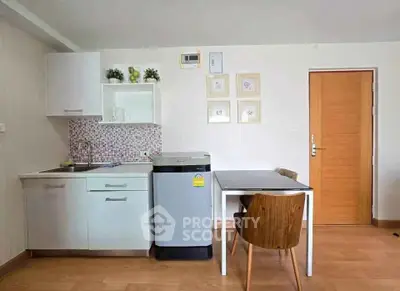 Charming kitchen with modern appliances and cozy dining area in a stylish apartment.