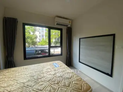 Cozy bedroom with large window and air conditioning in modern apartment
