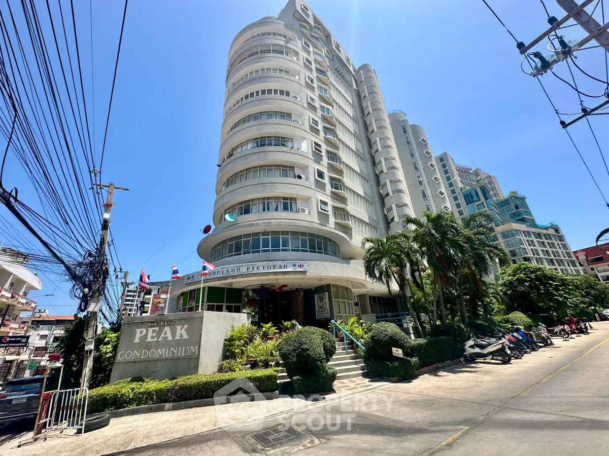 Stunning view of Peak Condominium with modern architecture and lush landscaping, perfect for urban living.