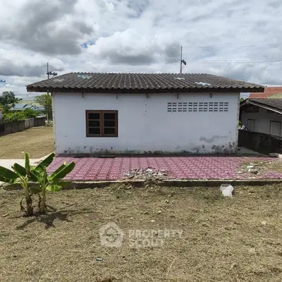 Charming rural house with tiled patio and spacious yard, perfect for countryside living.