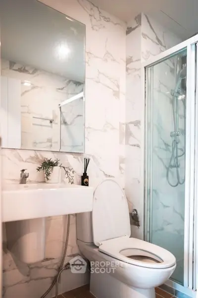 Modern bathroom with marble walls and glass shower enclosure