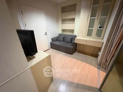 Cozy living room with modern sofa and built-in storage in a compact apartment.