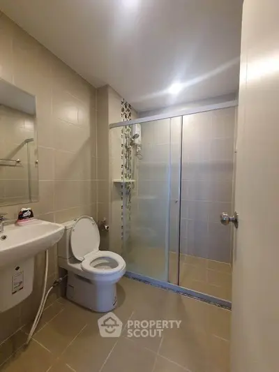 Modern bathroom with glass shower and sleek fixtures in a contemporary apartment.