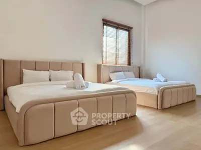 Spacious bedroom with two elegant beds and natural light