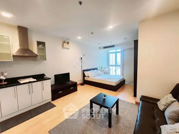 Modern studio apartment with open layout, featuring a cozy living area, sleek kitchen, and comfortable bed.