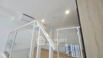 Modern loft bedroom with sleek glass railing and air conditioning
