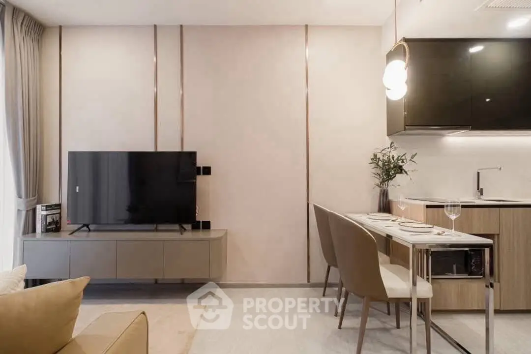 Modern living room with sleek TV unit and stylish dining area in open layout apartment.