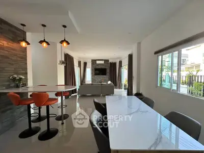 Spacious modern living room with elegant dining area and stylish lighting in a contemporary home.