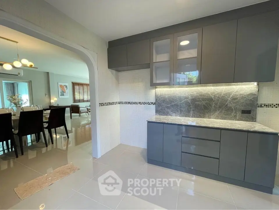 Modern kitchen with sleek cabinetry and open layout to dining area