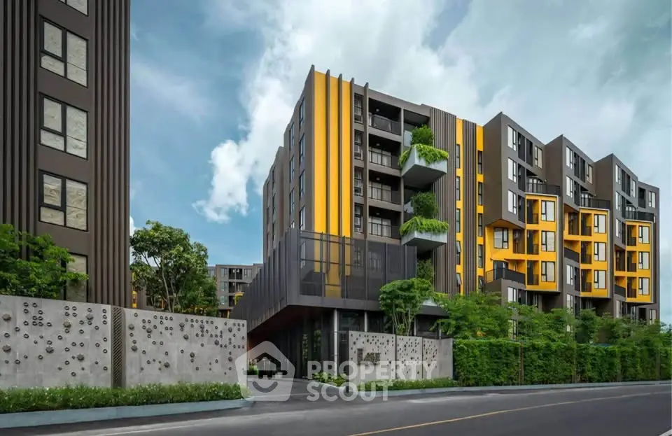 Modern apartment building with vibrant yellow accents and lush greenery