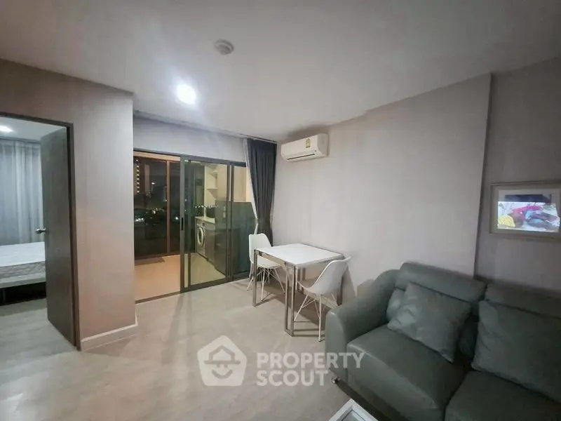 Modern living room with balcony access and air conditioning in a stylish apartment.
