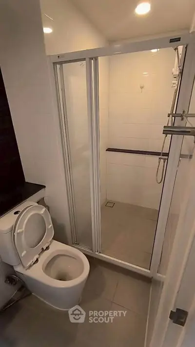 Modern bathroom with glass shower enclosure and sleek fixtures.