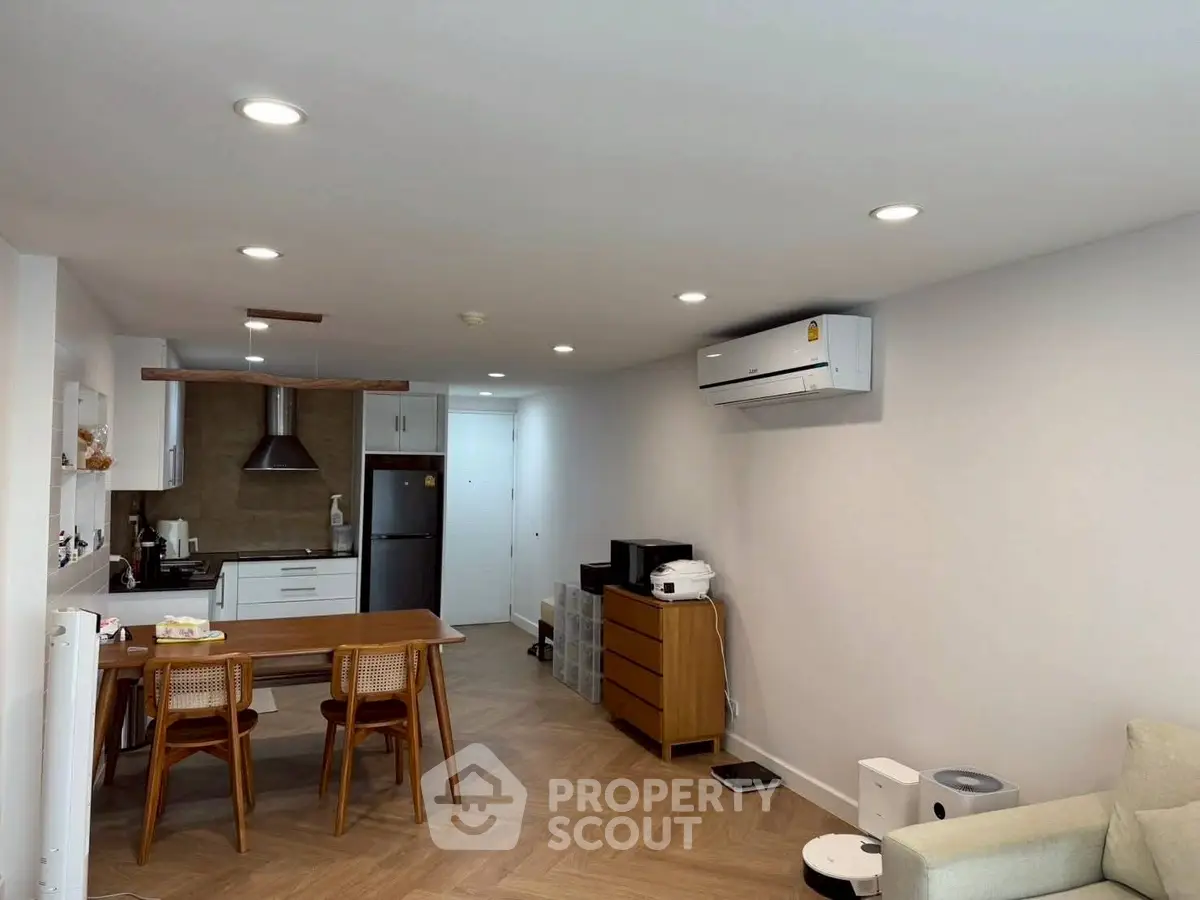 Modern open-layout kitchen and living area with sleek appliances and stylish decor.