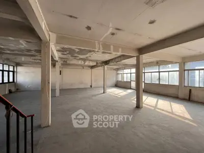 Spacious industrial-style open floor plan with large windows and abundant natural light.
