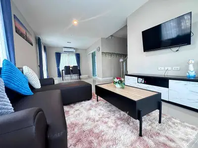 Modern living room with plush rug and wall-mounted TV in stylish home.