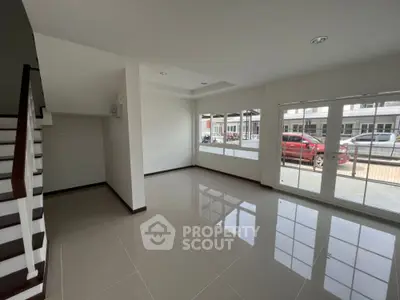 Spacious modern living room with large windows and glossy tiled floor