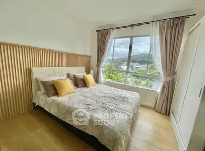 Bright bedroom with large window and scenic view, featuring cozy bedding and elegant curtains.