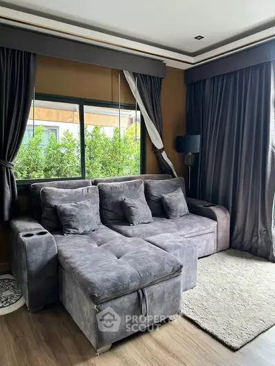 Cozy living room with plush gray sofa and large window view