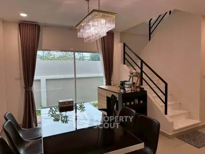 Modern dining area with elegant chandelier and staircase in stylish home