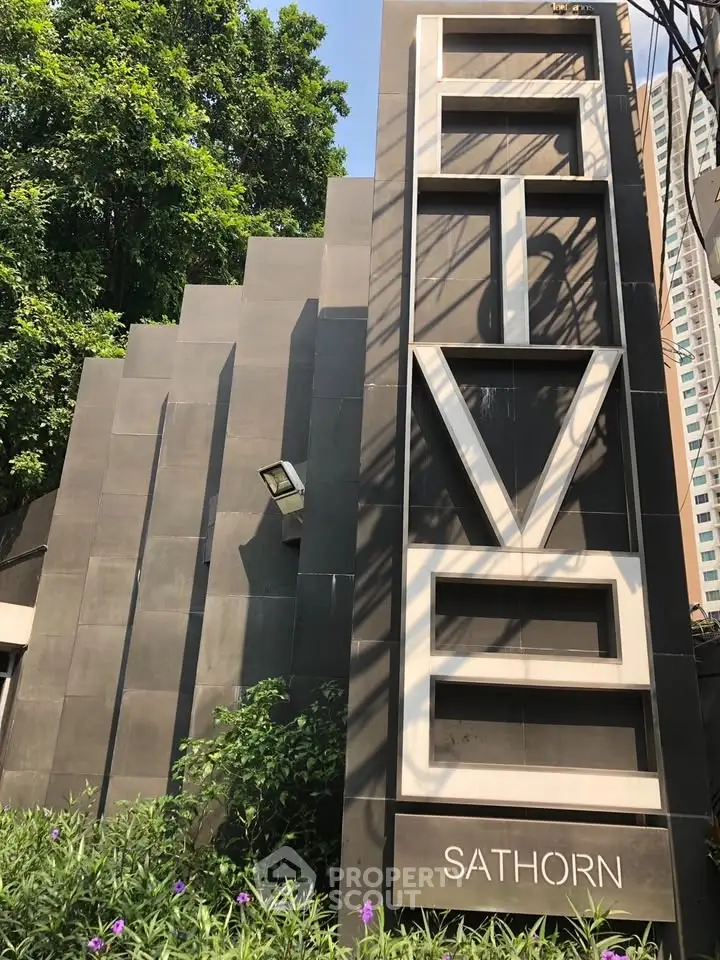 Modern building exterior with sleek design and lush greenery in prime urban location.