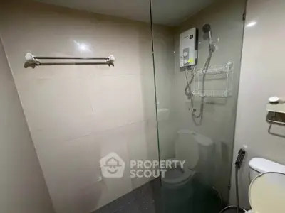 Modern bathroom with glass shower enclosure and wall-mounted showerhead.