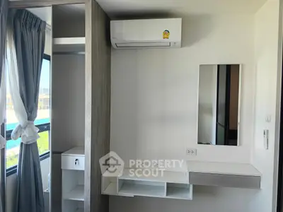 Modern bedroom with air conditioning and built-in storage solutions.
