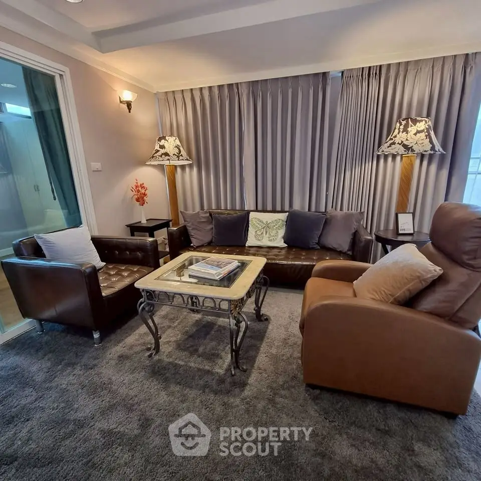 Elegant living room with leather sofas and stylish lamps, perfect for cozy gatherings.