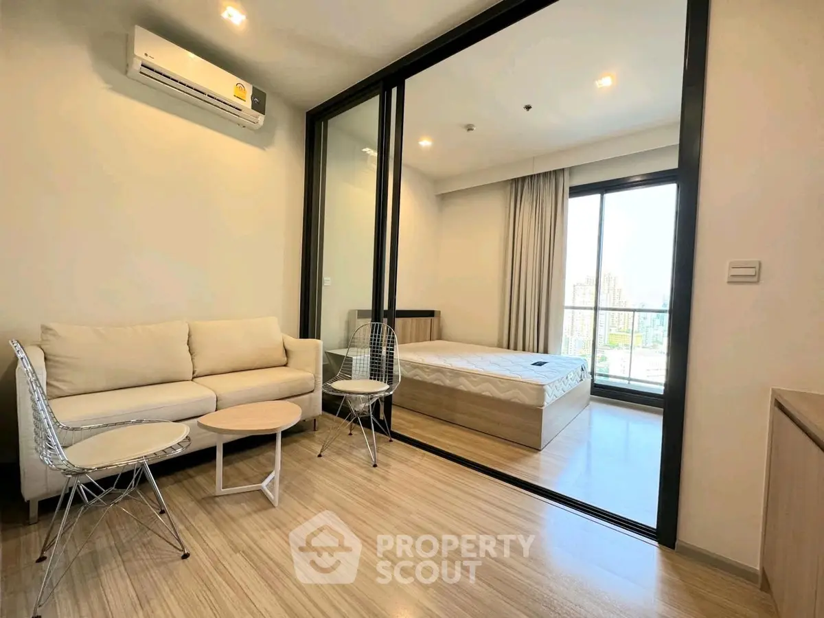 Modern apartment with cozy living room and bedroom, featuring sleek furniture and natural light.